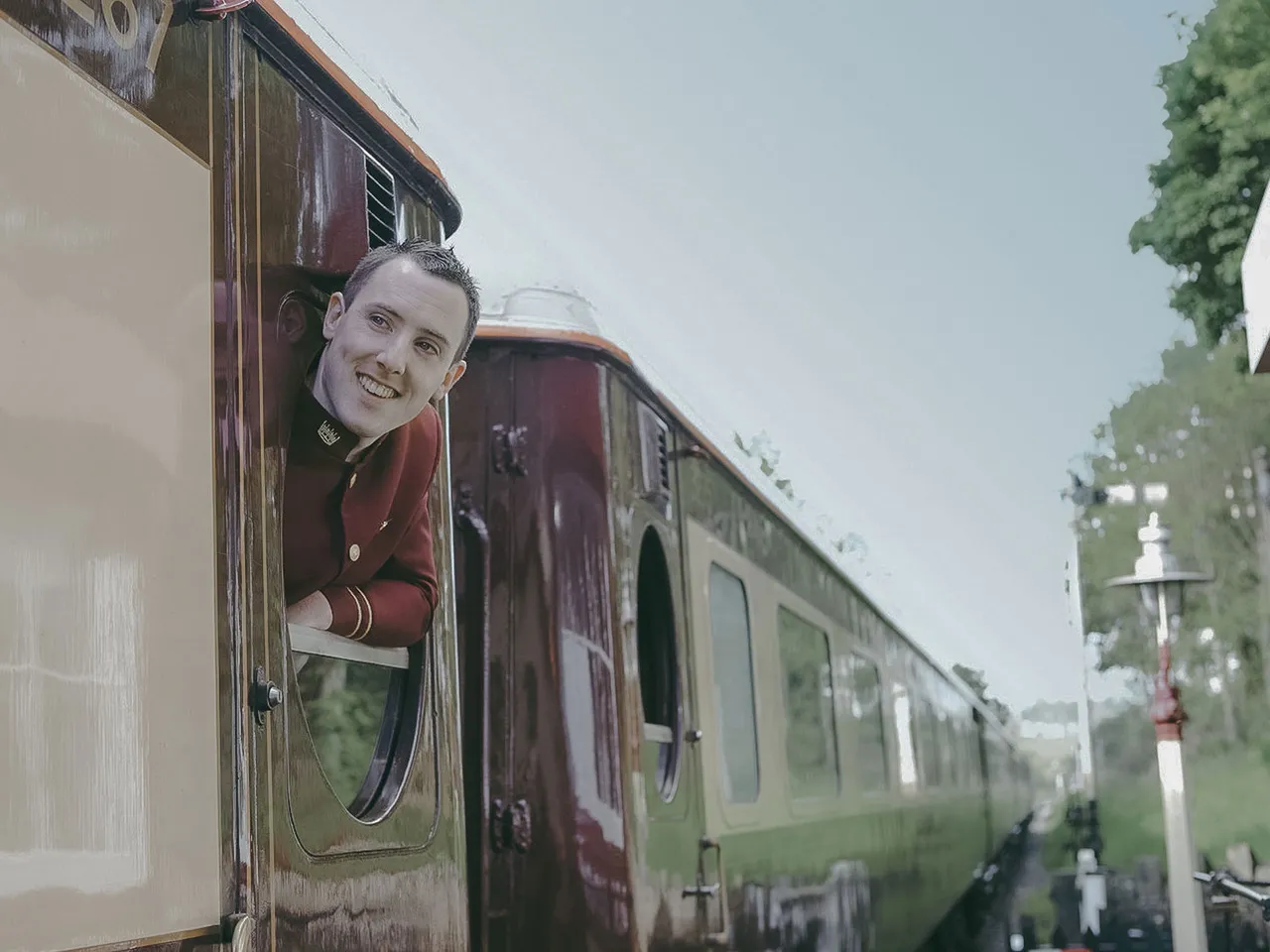 Steward souriant passant la t&ecirc;te par la fen&ecirc;tre du wagon Northern Belle