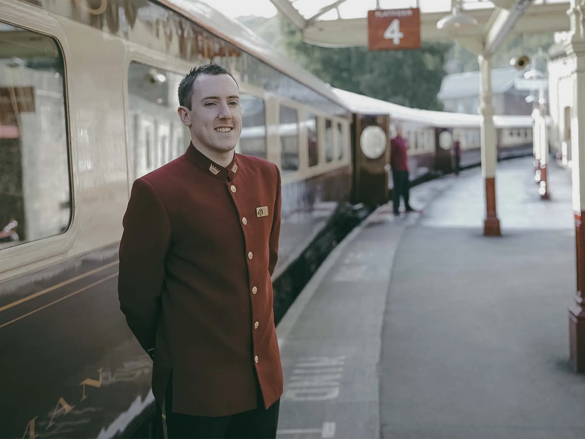 Steward en uniforme bordeaux sur le quai, train Northern Belle