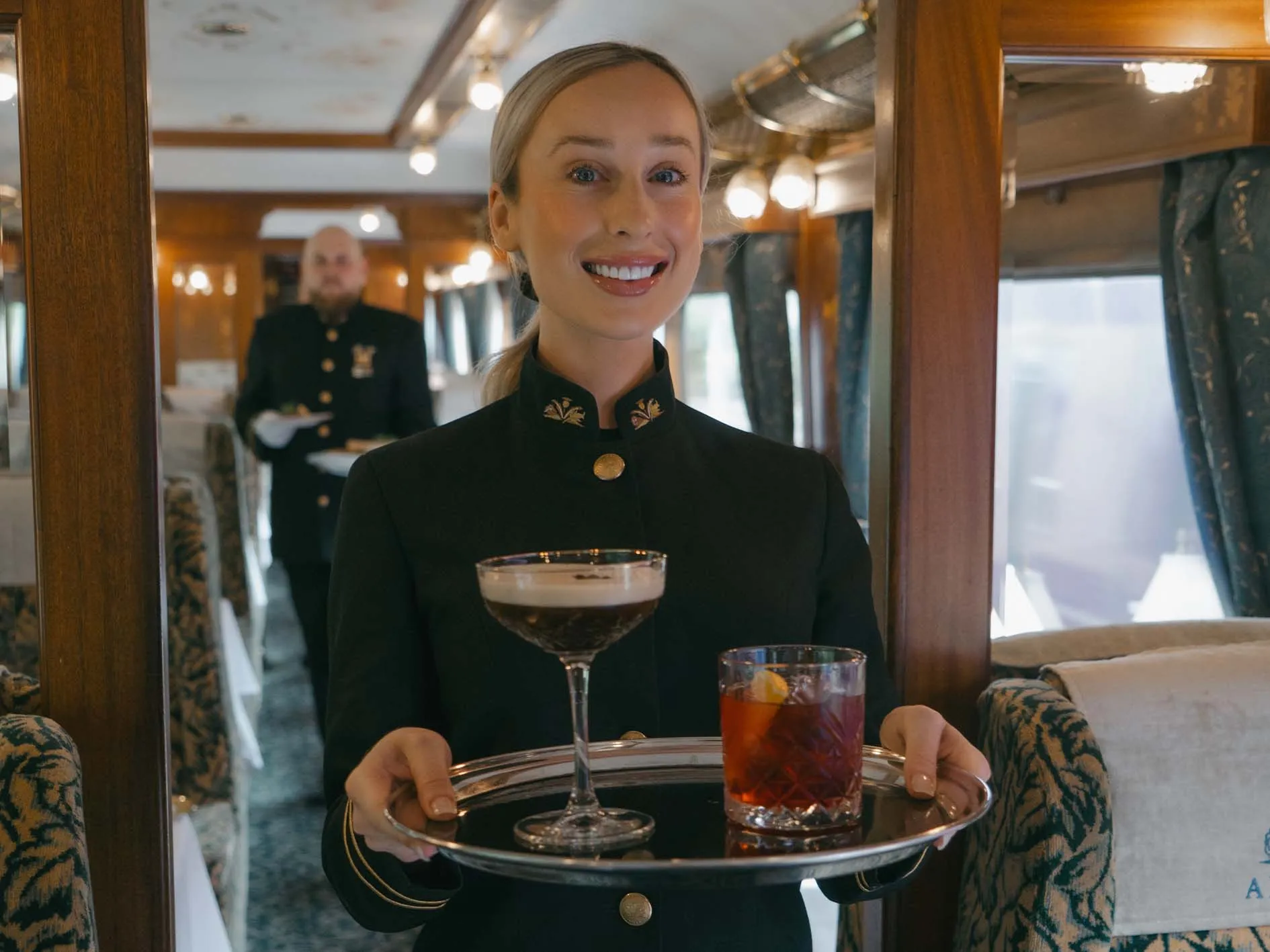 Stewardesse portant des cocktails sur plateau argent dans le Northern Belle