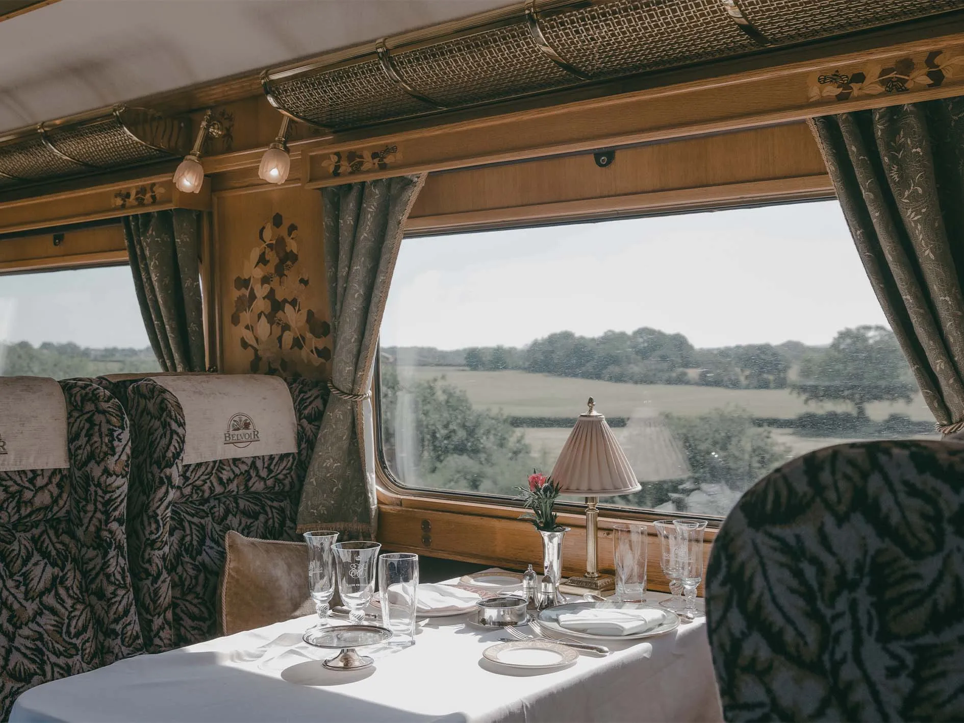 Table dress&eacute;e dans le wagon Belvoir du Northern Belle, vue sur la campagne anglaise