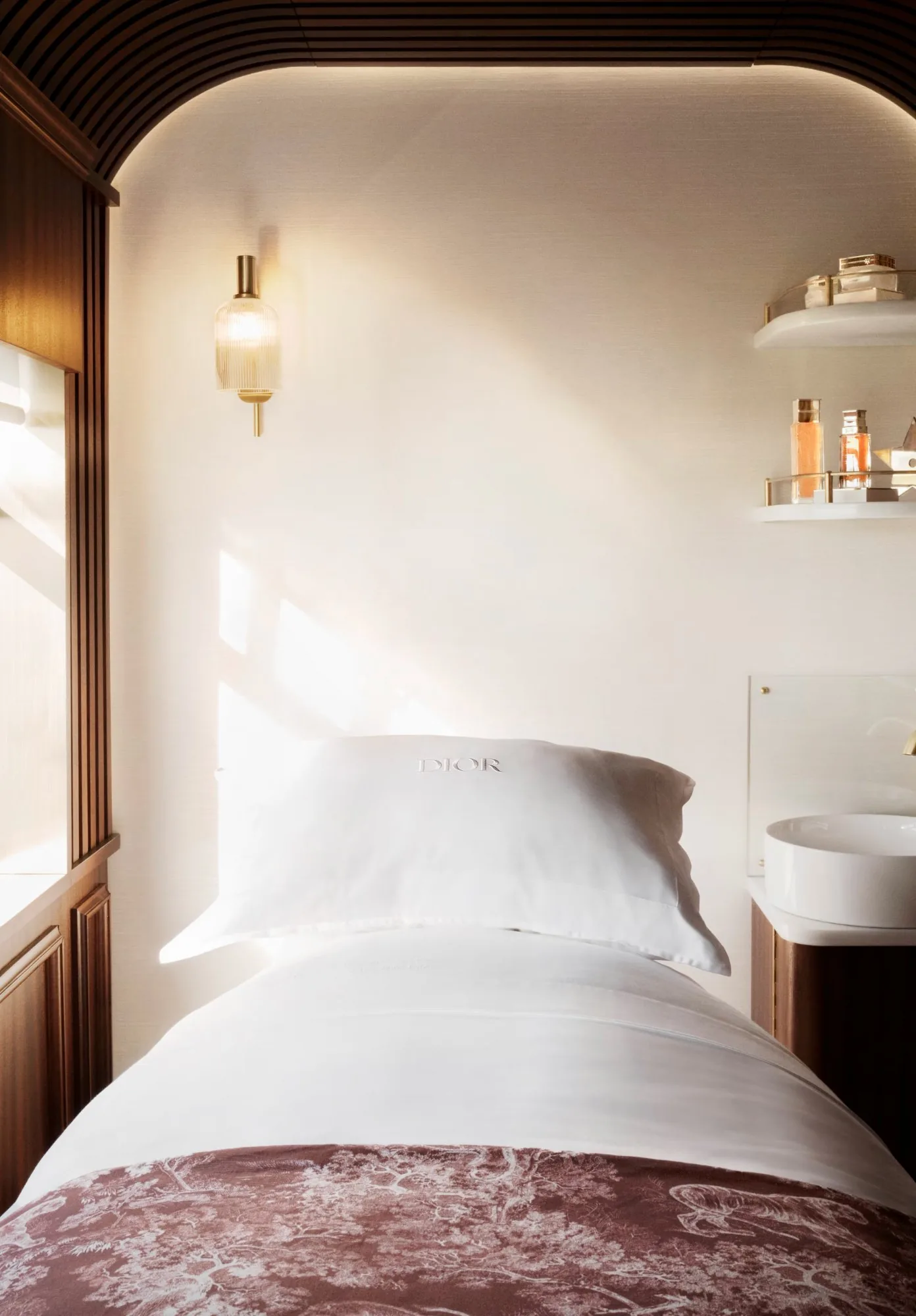 Table de soin du Dior Spa &agrave; bord du Royal Scotsman, oreiller blanc et boiseries de c&egrave;dre naturel &mdash; premier spa ferroviaire d'Europe