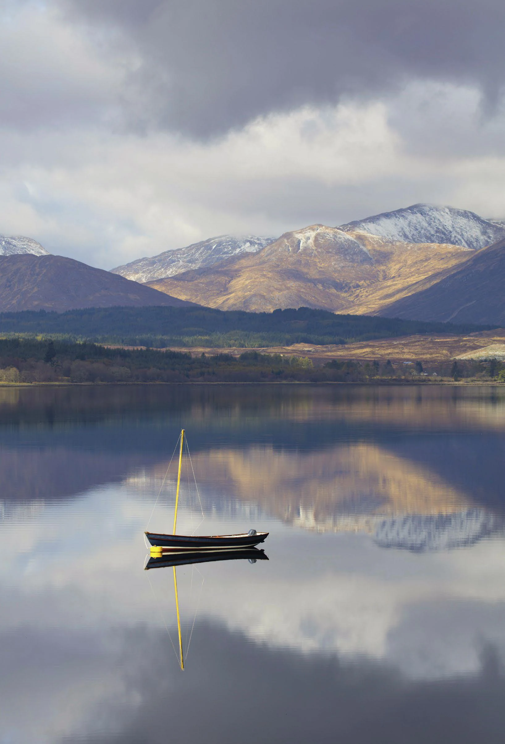 Loch &eacute;cossais aux reflets parfaits des montagnes &mdash; travers&eacute; par le Royal Scotsman dans les Highlands