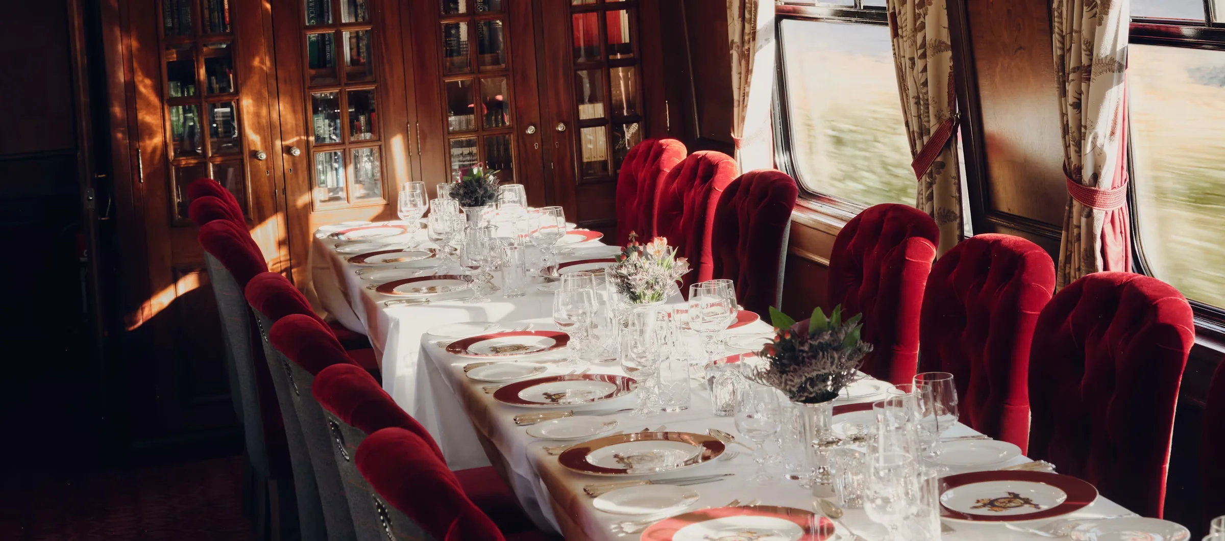 Wagon-restaurant du Royal Scotsman dress&eacute; pour le d&icirc;ner, fauteuils en velours rouge, argenterie et cristal
