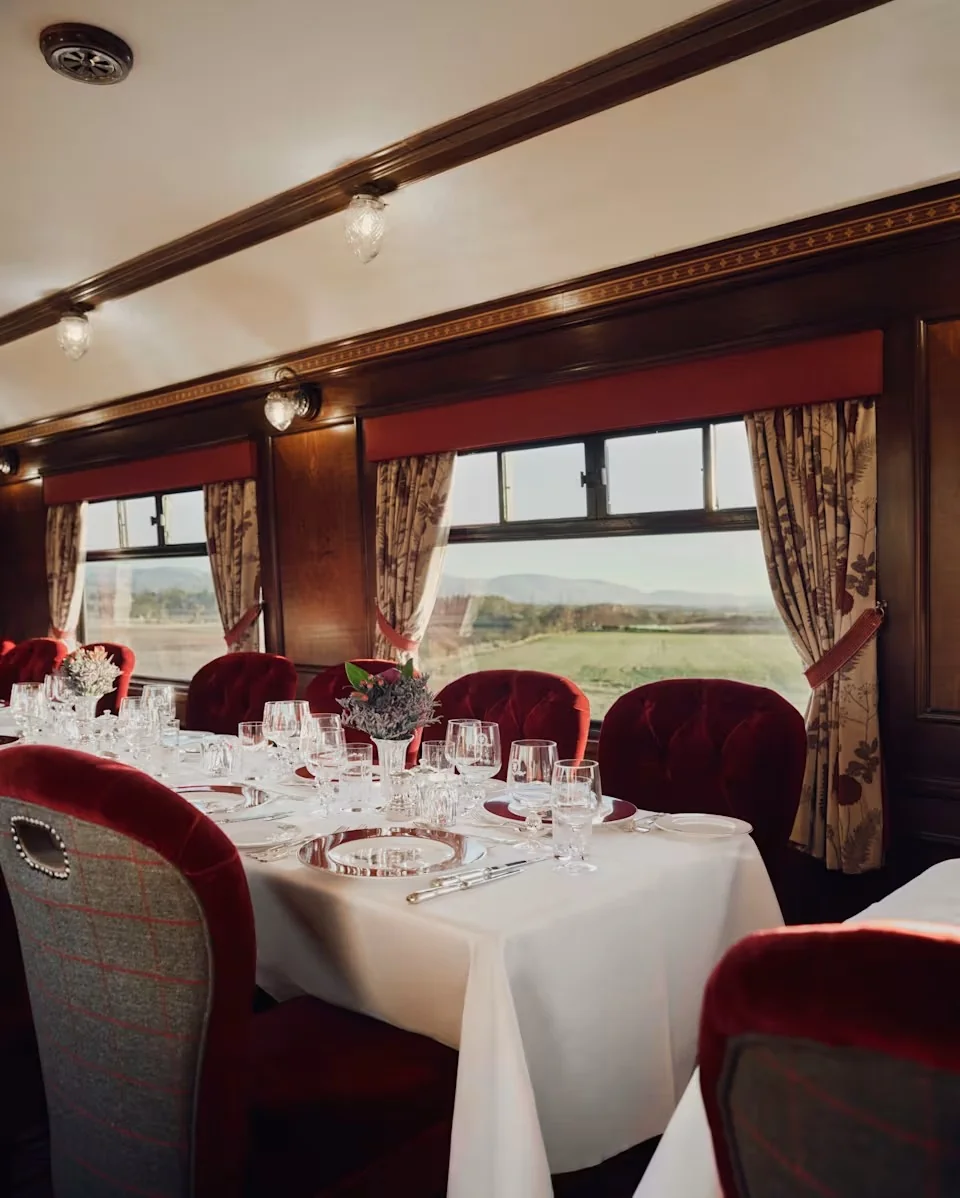 Table dress&eacute;e dans le wagon-restaurant du Royal Scotsman avec vue panoramique sur les Highlands &eacute;cossais